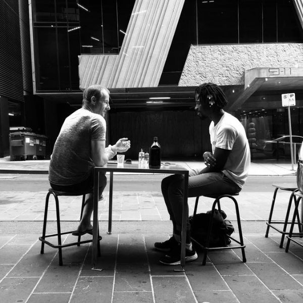 Datos inútiles. Fotografía de dos hombres conversando en un fondo blanco y negro