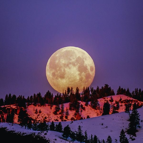 Luna naranja iluminando montañas