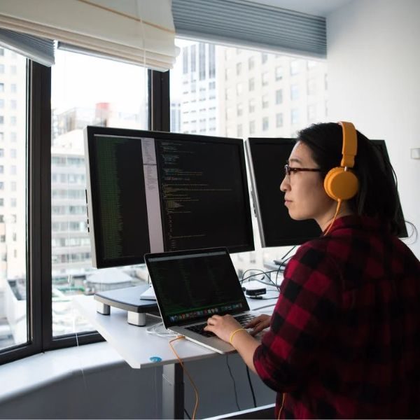 Ingenierías representada en una mujer frente a varias computadoras